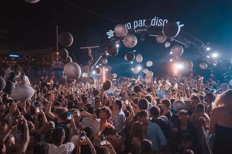 VIP guests at a Mykonos nightclub with illuminated dancefloor during Mykonos island nightlife experience